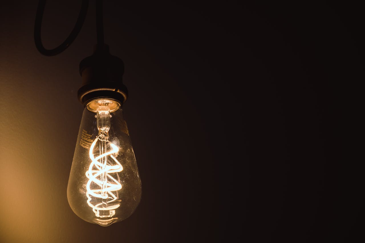 Ambientes que se adaptan a tu ritmo de vida<font dir="auto" style="vertical-align: inherit;"><font dir="auto" style="vertical-align: inherit;">.</font></font> Close-up of a glowing Edison light bulb showcasing its intricate filament.